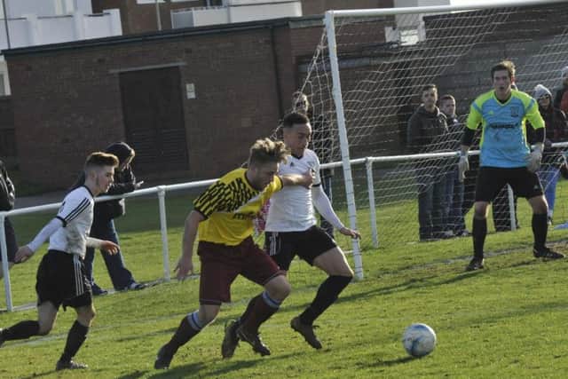 Little Common forward Jamie Crone is closely watched by Bexhill United defenders Ashley Kidman and Kyle Holden. Picture by Simon Newstead