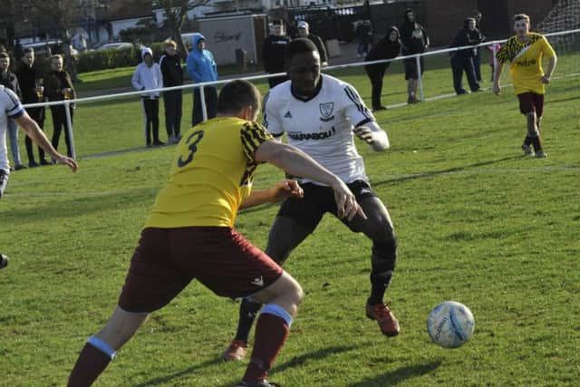 Little Common full-back Steve Mote tries to find a way past Bexhill United midfielder Georges Gouet. Picture by Simon Newstead