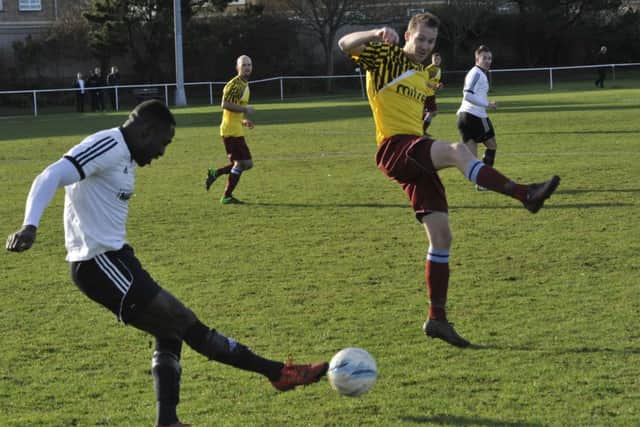 Little Common striker Lewis Hole attempts to block Georges Gouet's ball forward