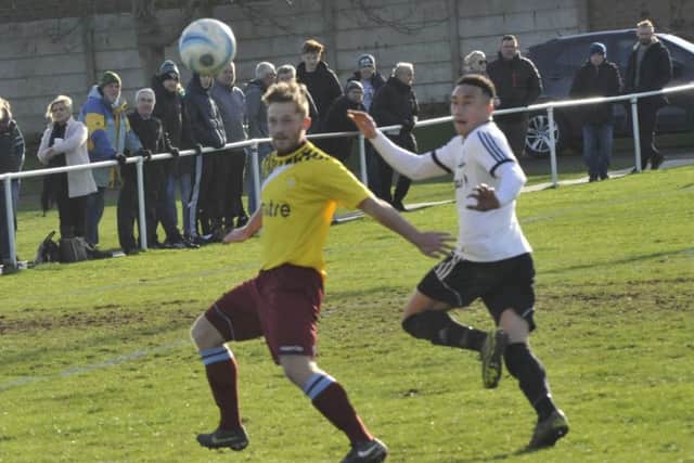 Little Common forward Jamie Crone tries to hold off Bexhill United defender Ashley Kidman