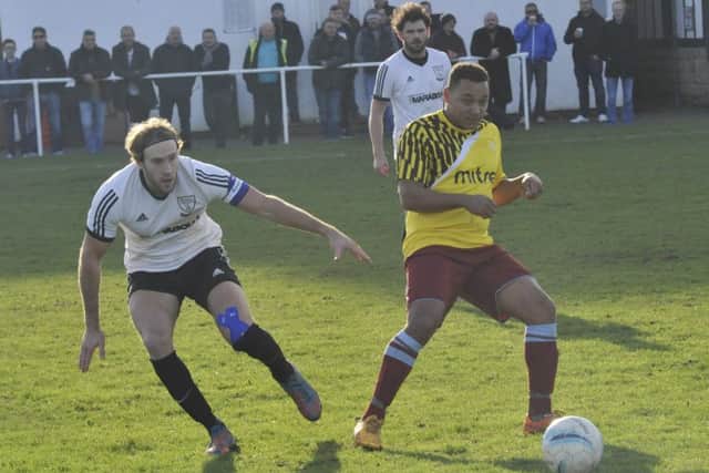 Bexhill United captain Billy Trickett keeps a close eye on Wes Tate