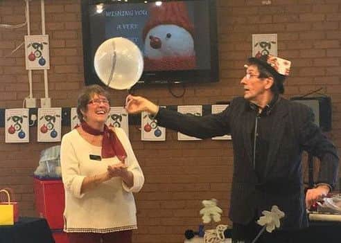 Club co-ordinator Jeanie Dickenson with magician John Beales