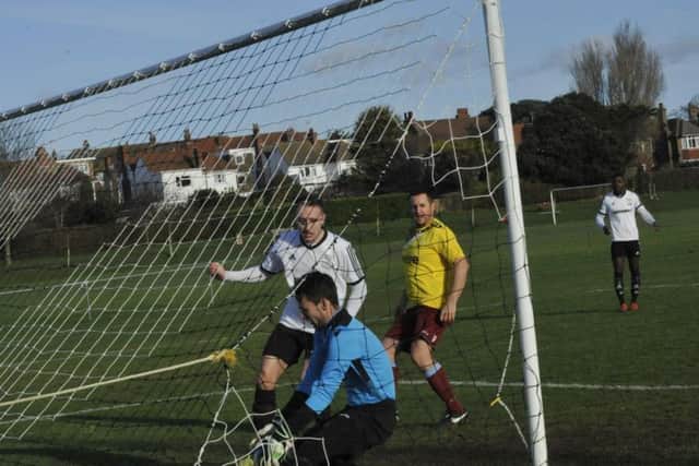 Little Common goalkeeper Matt Cruttwell can't quite prevent Bexhill United taking an early lead in the Boxing Day derby. Picture by Simon Newstead