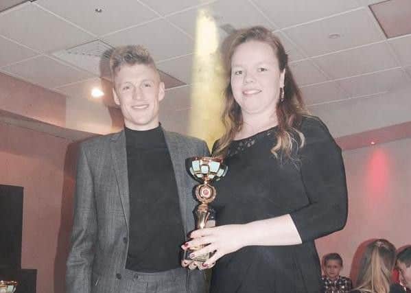 Louisa James clutches her trophy alongside Adam Clarke.