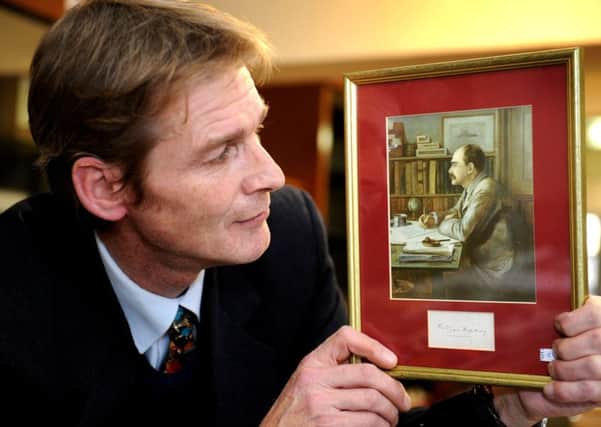 Auctioneer Paul Campbell is selling a collection of more than 500 signatures from iconic historical figures from the past five centuries. Holding Rudyard Kipling's signature and portrait. Picture: Steve Robards