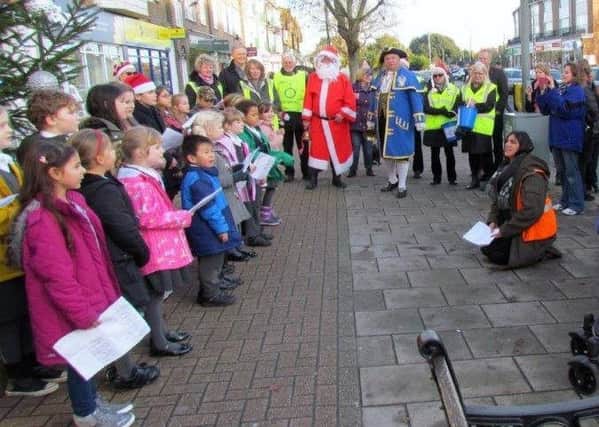Shoppers in Goring gather to hear the children of Elm Grove Primary School sing carols