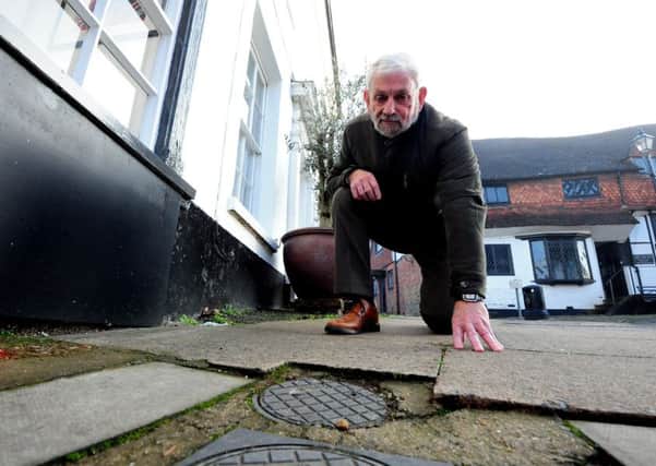 Graham Pooley with the broken paving stone in Knockhundred Row