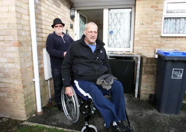 Michael Gauntlett outside the bungalow he is waiting to move into, with helper Stephen Boyd