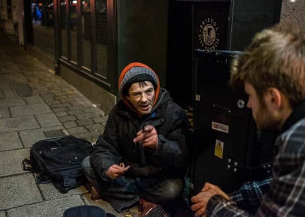 Owain interviews a homeless man on the street. Picture by Ken Abbott