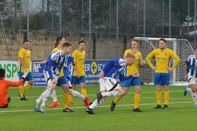 Tome Graves (centre) runs away after opening the scoring. Lancing v Haywards Heath Town. Picture by Grahame Lehkyj