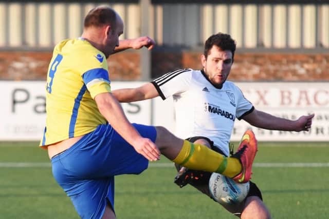 Bexhill United defender Craig McFarlane goes in for a challenge with Langney's Shane Saunders. Picture courtesy Jon Smalldon