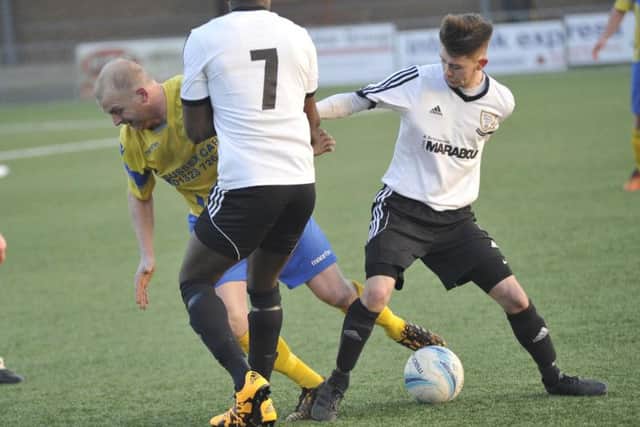 Bexhill United duo Kyle Holden and Georges Gouet combine to stop Paul Rogers. Picture by Simon Newstead
