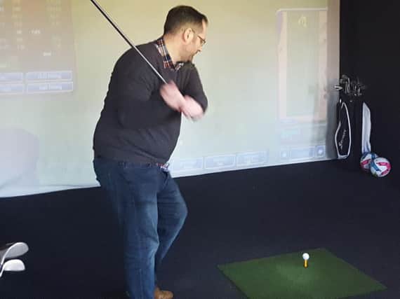 Mark Dunford tries out the golf simulator at Sports Sim