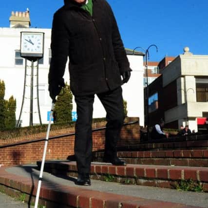 MP Tim Loughton attempting to descend stairs wearing a pair of glasses which simulate being partially sighted