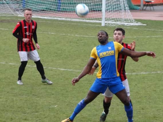 Bexhill United wide player Georges Gouet holds off an AFC Varndeanians opponent. Picture courtesy Mark Killy