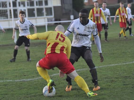 Bexhill United wider player Georges Gouet keeps a close eye on a Lingfield opponent. Pictures by Simon Newstead