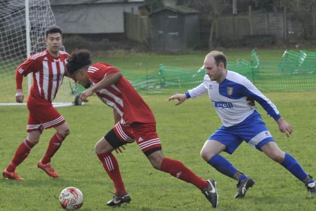 A Hawkhurst player tries to turn away from a Sedlescombe opponent.