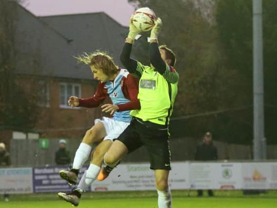 Harry Stannard challenges Horsham's former Hastings United goalkeeper Josh Pelling in the reverse fixture. Picture courtesy Scott White