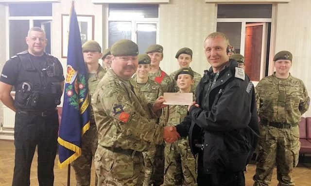 Sgt Prince is seen presenting the cheque to Colour Sergeant Sawyer, with a group of cadets in the background. On left of photo is Chris Biddiss, who is also a full-time Constable with Sussex Police