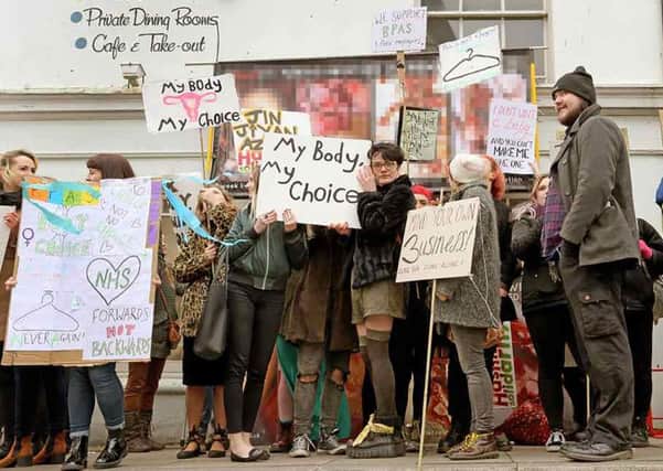 Pro-Choice demonstrators try to cover up anti-abortion posters at a protest in Hastings. Photo by Richard Platt SUS-170215-133547001