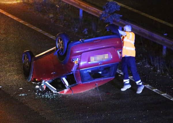 A red Mini Cooper overturned. All pictured Eddie Mitchell