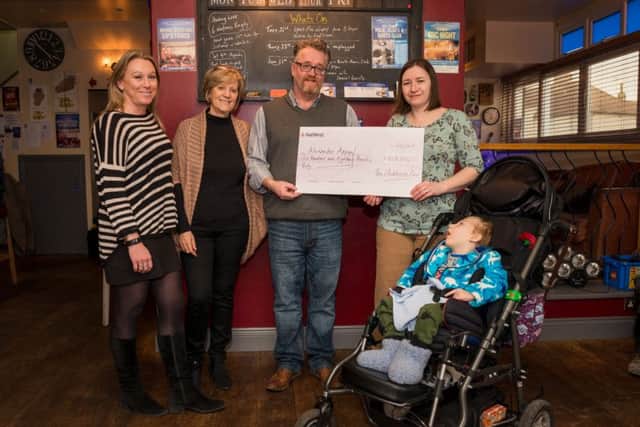 Emma Weaver (left) and Liz Galloway of Caldotec, with Colin Bradshaw from the Clockhouse Bar giving a cheque to Alexander and Kirsty. Picture: Bob Billingshurst