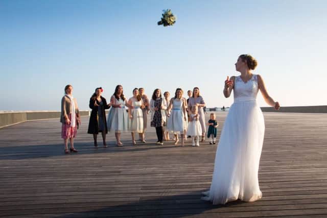 Holly throws the bouquet on the pier. Photo by Simon Booth Photography SUS-170222-145102001