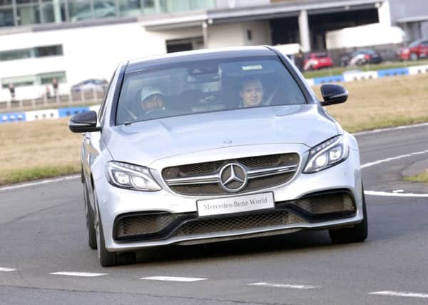 Lewis Hamilton takes Sam Wilson around the track at Mercedes-Benz World