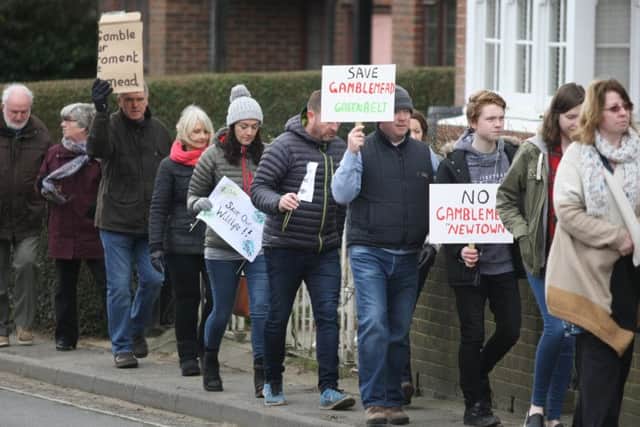 Despite the cold weather residents held up banners and posters on the ordered walk. Picture: Derek Martin