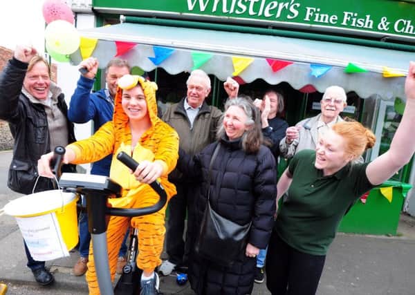 Jack Parker, 16, takes his turn to do a sponsored cycle outside Whister's fish and chip shop. Picture: Kate Shemilt ks17000106-1