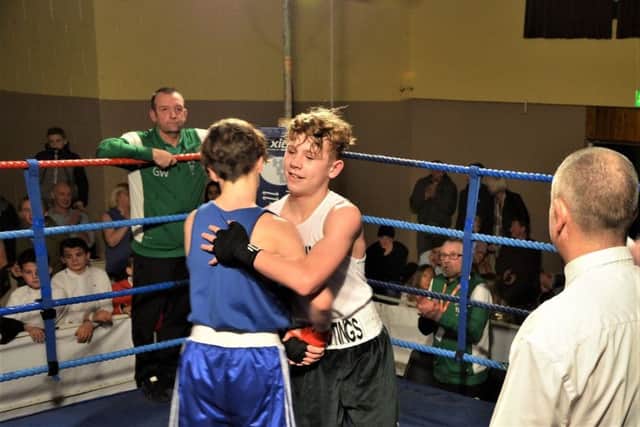 Two young boxers share a sporting embrace at the end of their bout. Picture courtesy Sid Saunders
