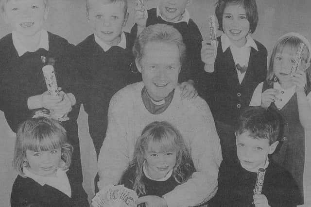 Rev Alastair Cumming, of St Johns Church, Copthorne, with some of the children who filled empty Smarties tubes with coins