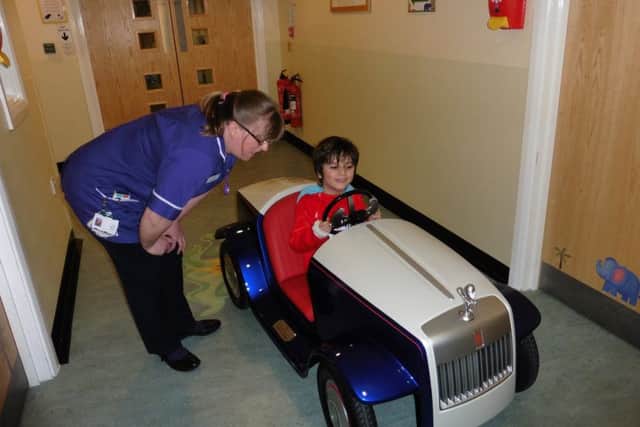 George Burley, 6, has a test run in the car at the pediatric day unit in St Richard's Hospital, with ward matron Sue Nicholls.