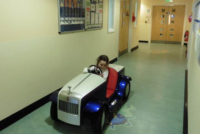 Willow Stent, 5, has a turn in the Rolls-Royce at the pediatric day unit.