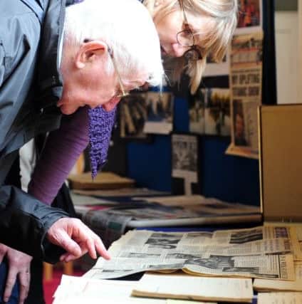 Brian Handscomb and Erica Lynn looking at old newspaper cuttings ks170135-3