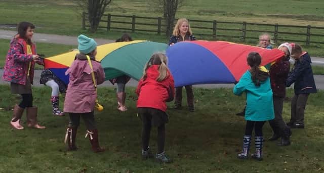The Girl Guides playing with the parachute