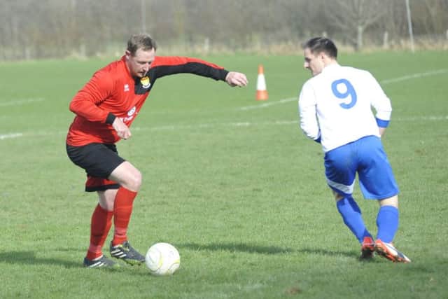 Bexhill AAC defender Andy Atkin brings the ball away from a Sedlescombe Rangers opponent.