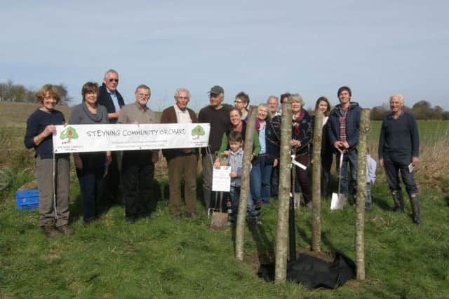 Celebrating the completion of the planting, including large stakes to help protect the trees against deer browsing