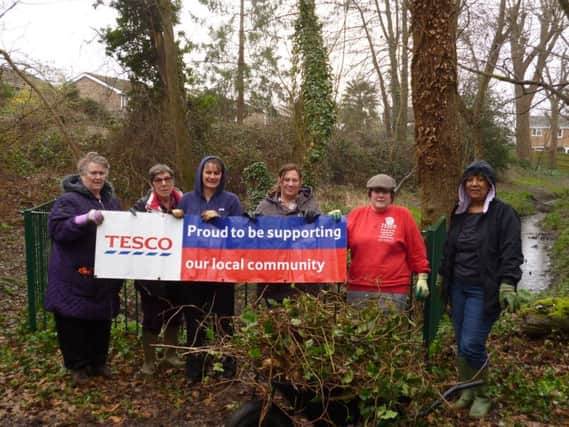 Tesco staff, the neighbourhood wardens, Parish Council staff and a resident volunteer help tidy up as part of the Pocket Park project