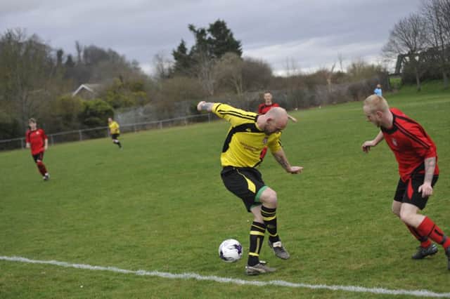 Rye Town wide player George Ball closes down an Icklesham Casuals opponent. Pictures by Simon Newstead