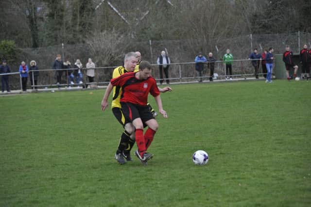 Rob Levett holds off an Icklesham Casuals defender.