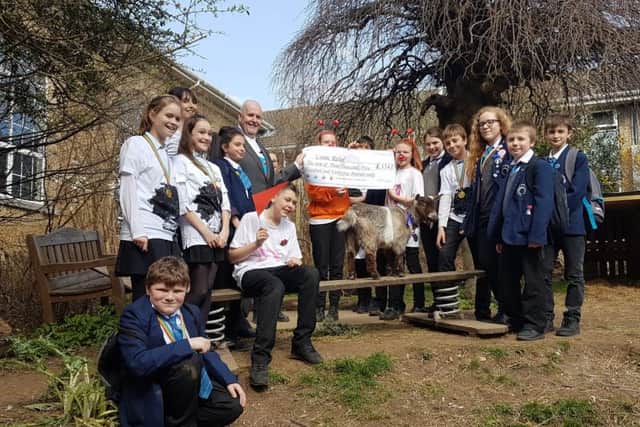 Headteacher William Deighan with students and one of the pygmy goats SUS-170324-155642001