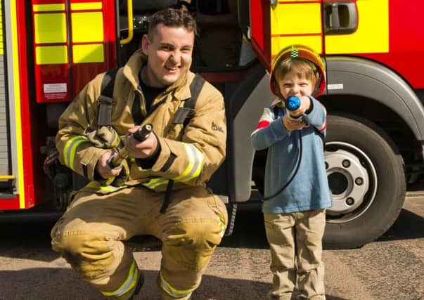 Finlay Bennett with a firefighter on Saturday (March 25). Picture: Eddie Howland SUS-170327-114450001