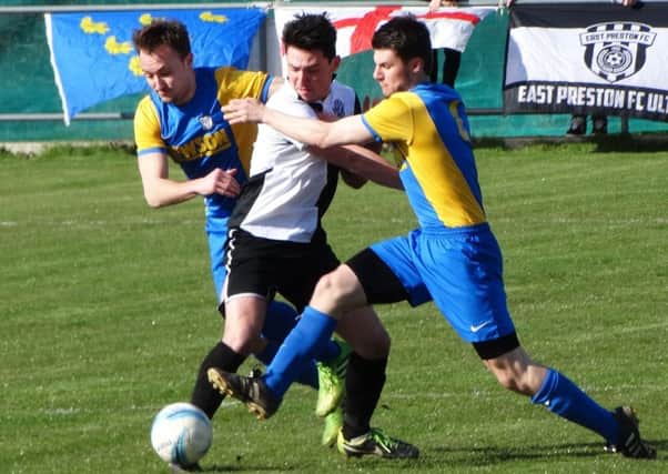 Bexhill United pair Gordon Cuddington and Connor Robertson sandwich an East Preston opponent during last weekend's 2-2 draw. Picture courtesy Mark Killy