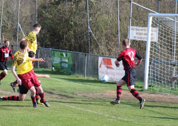 Lewis Hole (yellow shirt, nearest camera) scores Little Common's opening goal in last weekend's 2-2 draw at Saltdean United. Picture courtesy Catherine Gurney