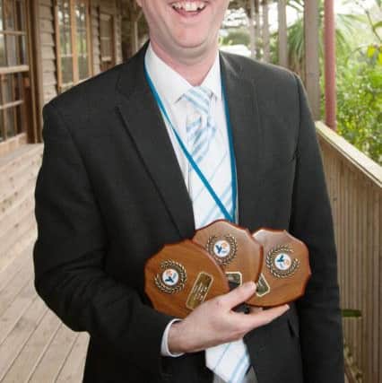 Phillip Potter, head teacher at Oak Grove College, with the trophies for best trade stand, best presentation and best company team programme