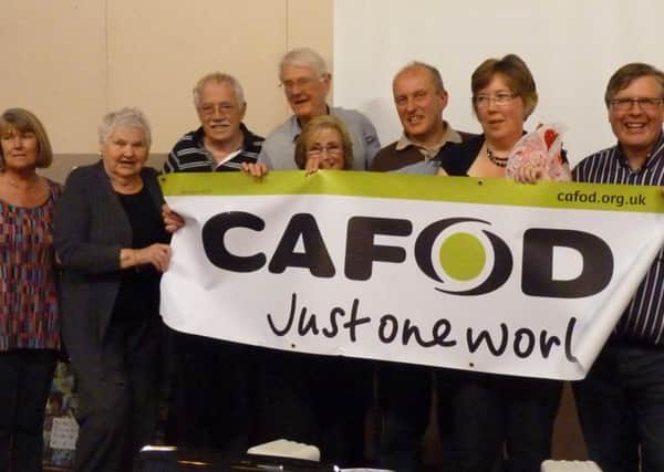 Lent Fast Day Soup Supper participants with a CAFOD banner