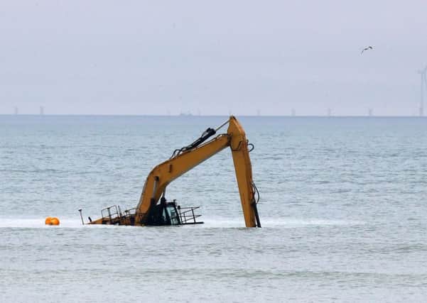 The digger is designed to keep its cabin above the water, but something appears to have gone wrong. Picture: Eddie Mitchell
