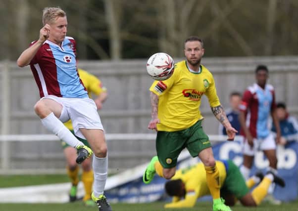 Hastings United captain Simon Johnson lays the ball off against Godalming Town. Picture courtesy Scott White