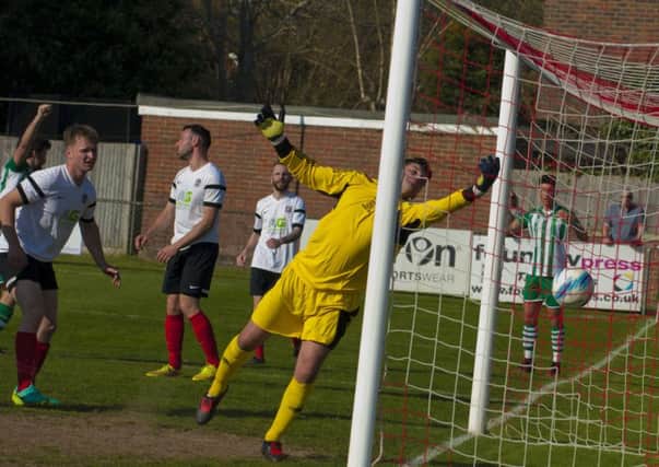 Horsham YMCA goalkeeper Mark Fox tries in vein to deny a Chichester City goal on Saturday. Picture by Tommy McMillan